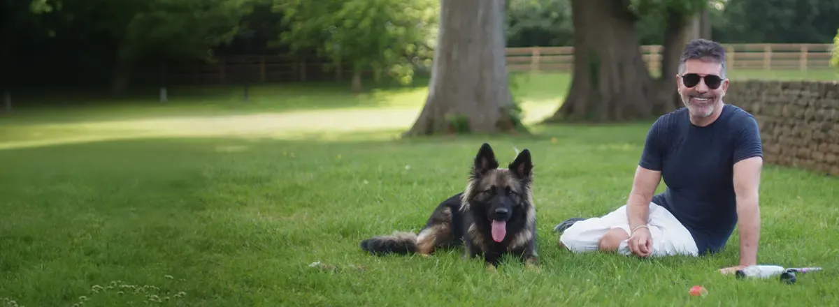 Simon Cowell with his large dog in the yard